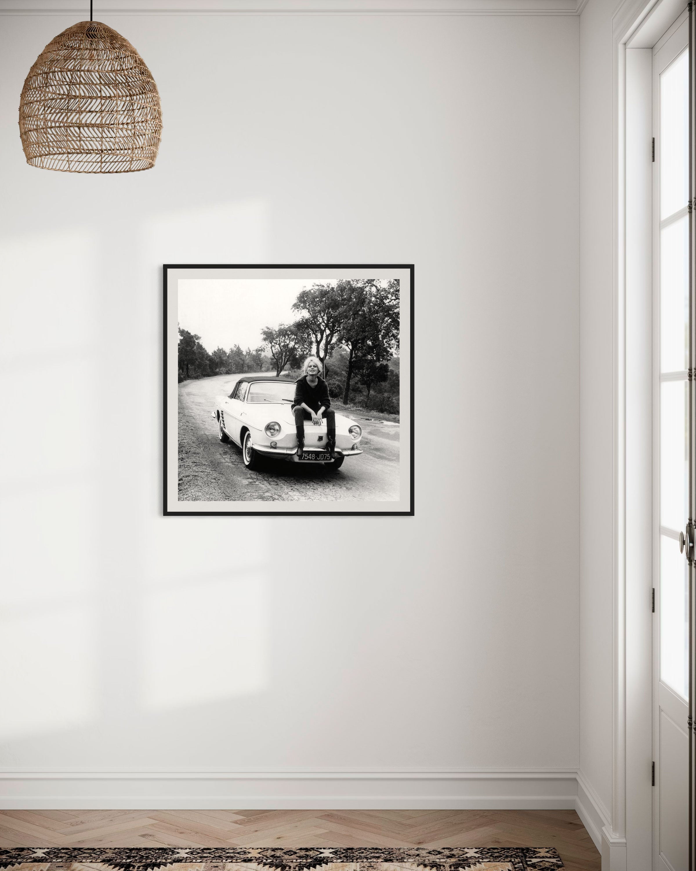 Brigitte Bardot assise sur sa voiture